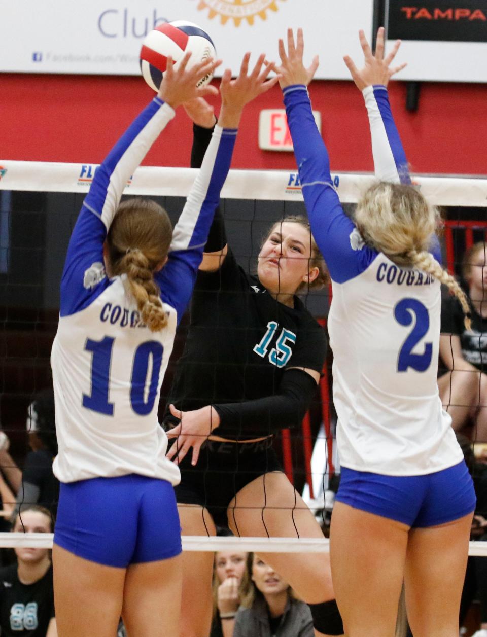 Jensen Beach ’s Jenna Simmons blast spike of outstretched arms of Falcons #10 Miriam Weintraub and #2 Ava Zehnder. Barron Collier vs Jensen Beach HS (Miami). FHSAA Volleyball Semi Finals at Polk State College in Winter Haven Fl. November 8th 2023 Photo by Calvin Knight