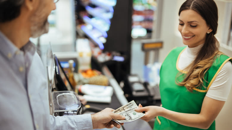 customer paying at grocery store checkout