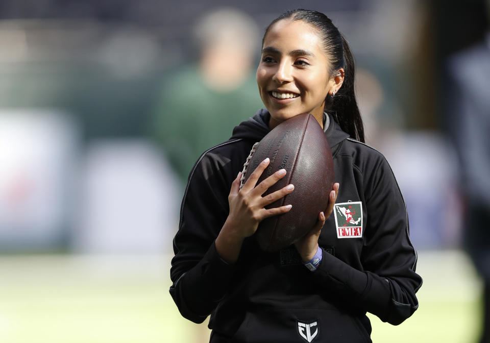 FILE - Team Mexico Women's Flag quarterback Diana Flores stands on the field before an NFL football game between the Green Bay Packers and the New York Giants at Tottenham Hotspur Stadium in London, Sunday, Oct. 9, 2022. (AP Photo/Steve Luciano, File)