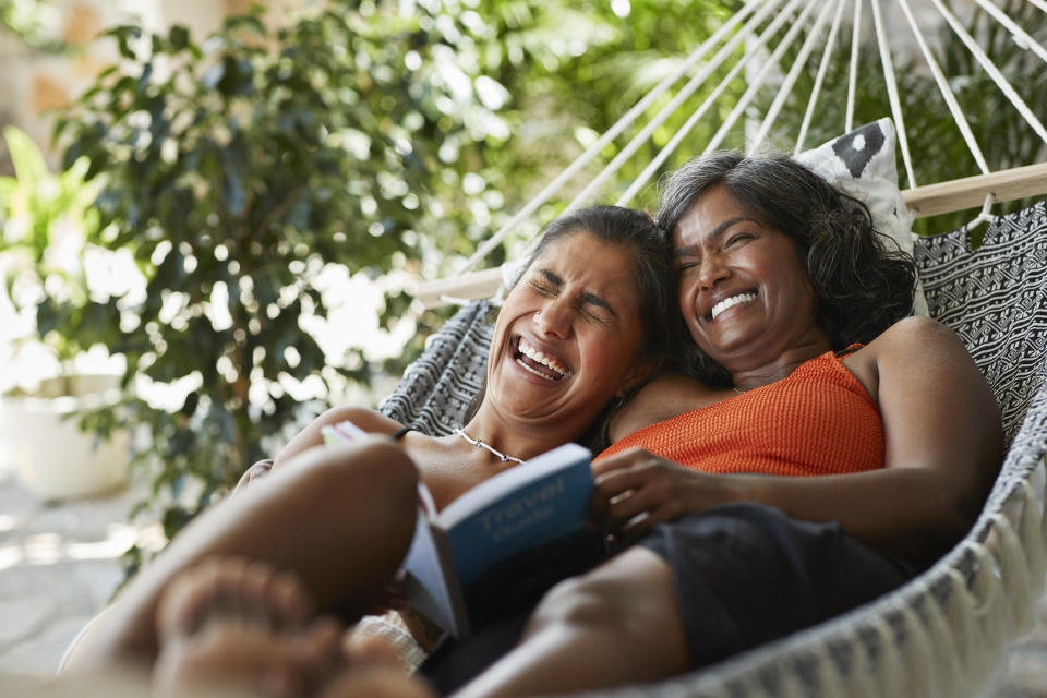 two people laughing in a hammock