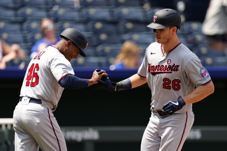 Minnesota Twins' Max Kepler (26) celebrates with third base coach Tony Diaz after hitting a solo home run during the sixth inning of a baseball game against the Kansas City Royals Sunday, July 4, 2021, in Kansas City, Mo. (AP Photo/Charlie Riedel)