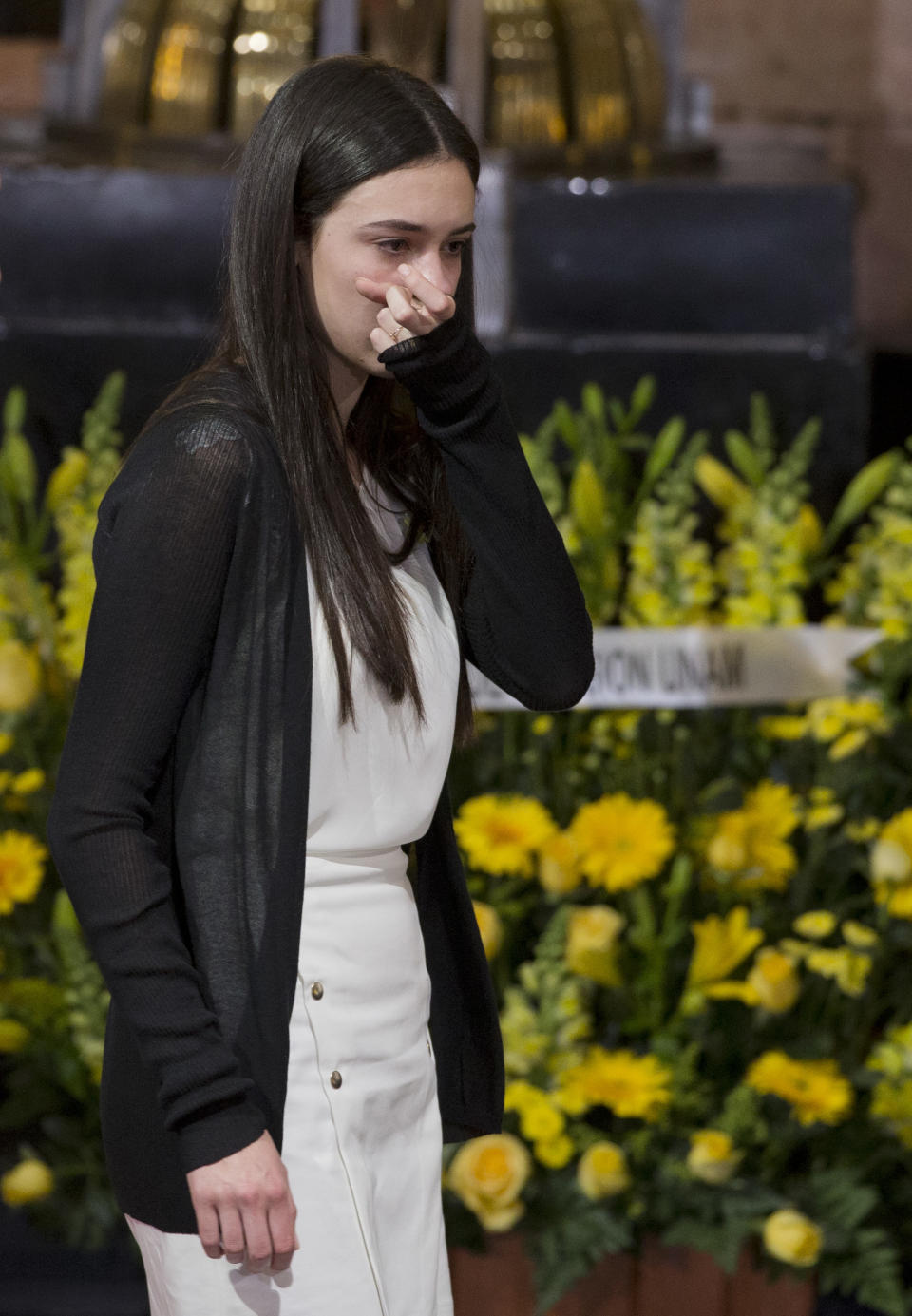 An unidentified guest wipes away tears during an homage to Colombian Nobel Literature laureate Gabriel Garcia Marquez at the Palace of Fine Arts in Mexico City, Monday, April 21, 2014. The ashes of Garcia Marquez arrived Monday at Mexico City's majestic Palace of Fine Arts to several minutes of thunderous applause from admirers paying tribute to the Colombian Nobel laureate, considered one of the greatest Spanish-language authors of all time. (AP Photo/Rebecca Blackwell)