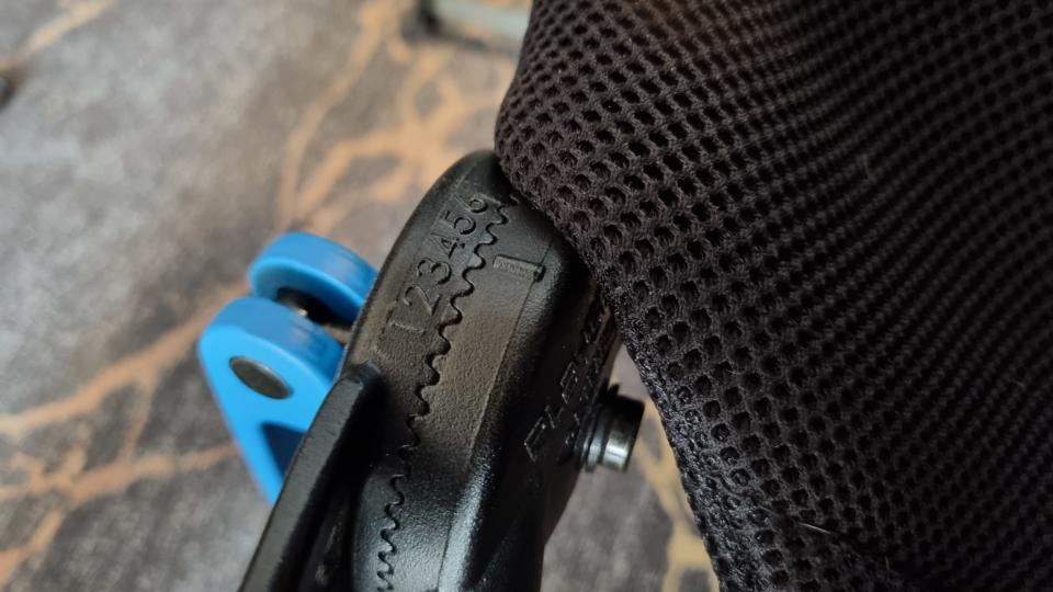 The left X-adapt hinge on the Logitech Playseat Challenge X, showing the internal hex bolt that needed to be tightened