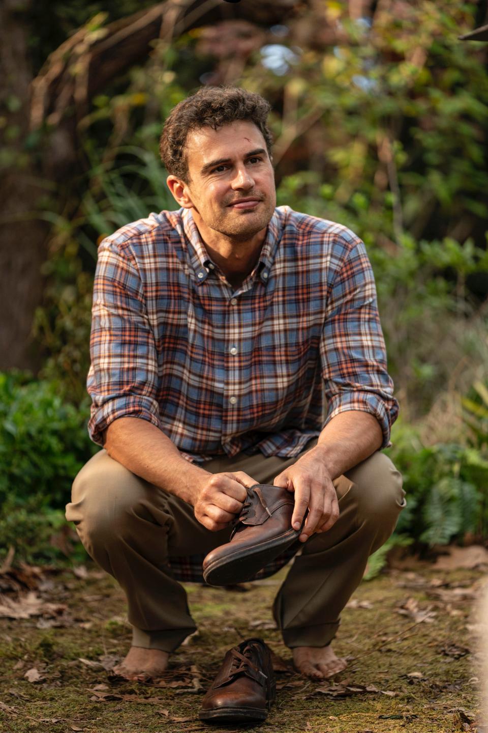 Henry (Theo James) puts on a shoe after another time landing.