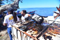 Volunteers take part in the clean up operation in Mahebourg, Mauritius Wednesday Aug. 12, 2020 surrounding the oil spill from the MV Wakashio, a bulk carrier ship that recently ran aground off the southeast coast of Mauritius. Anxious residents of this Indian Ocean island nation have stuffed fabric sacks with sugar cane leaves in an effort to stop the oil spill from reaching their shores. (AP Photo/Beekash Roopun-L'express Maurice)