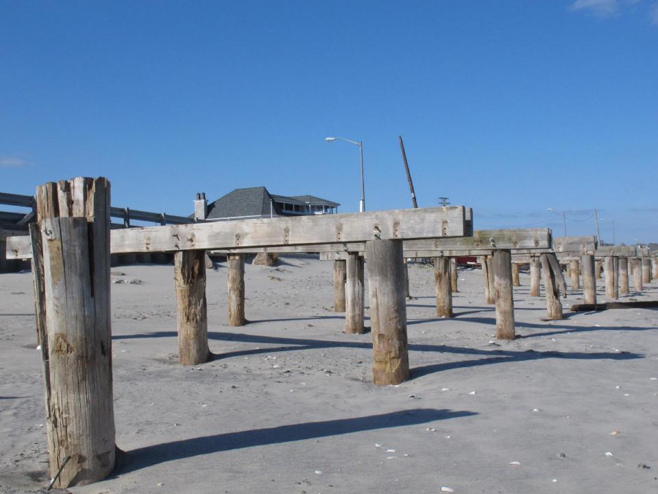 Support pilings for the Avon, N.J. boardwalk, shown here on Feb. 12, 2013, are all that is left of the walkway that was destroyed in Superstorm Sandy.Dogged by legal and environmental woes, Avon is lagging behind some other Jersey shore towns in terms of quickly rebuilding storm-damaged boardwalks. (AP Photo/Wayne Parry)