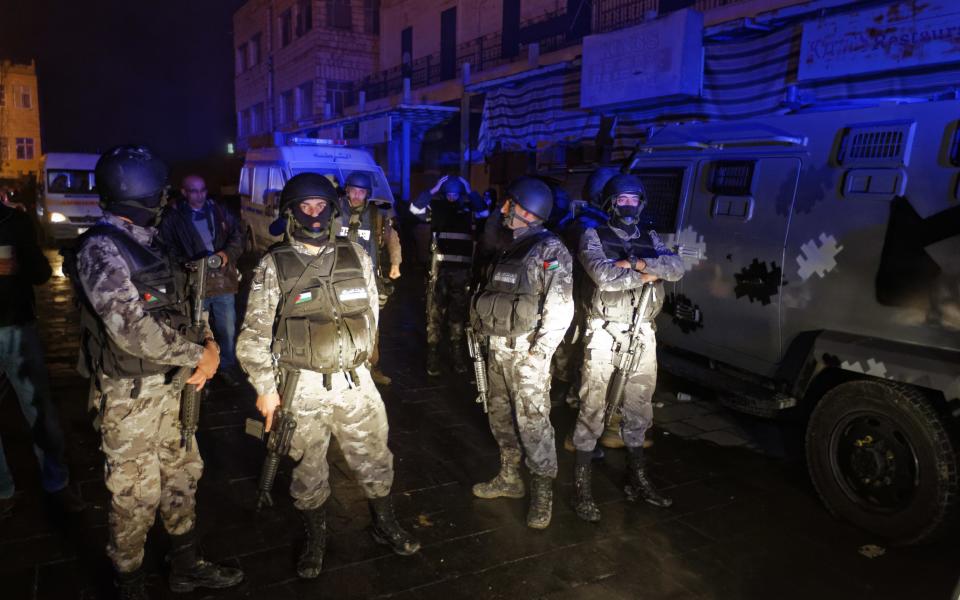 FILE -- In this Dec.18, 2016 file photo, Jordanian security forces stand next to their armored vehicle at the scene next to Karak Castle, during an ongoing attack, in the central town of Karak, about 140 kilometers (87 miles) south of the capital Amman, Jordan. The recent Islamic State shooting rampage at Karak Castle, a popular tourism site in Jordan, could signal a more aggressive campaign by the extremist group to destabilize the pro-Western kingdom. A senior security official says members of the Karak cell, who were killed during the attack, had planned New Year’s Eve attacks in Jordan, using five explosives belts. Jordan’s government tries to allay concerns, saying its security forces can contain any threat. (AP Photo/Ben Curtis, File)