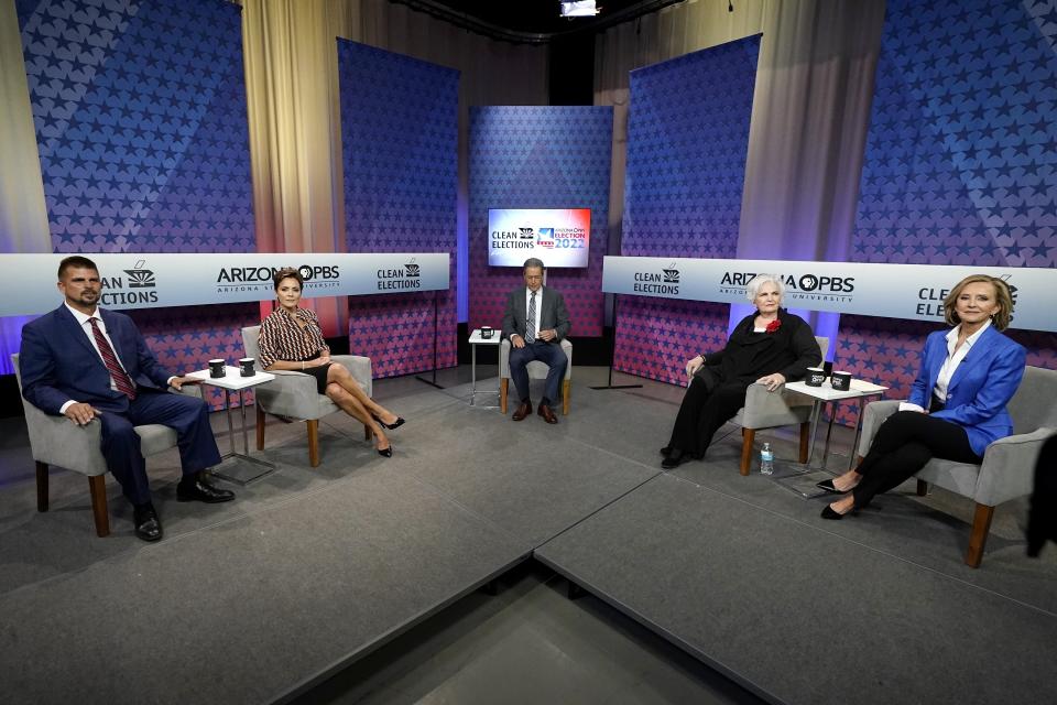 FILE - Republican candidates for Arizona governor from left to right, Scott Neely, Kari Lake, Paola Tulliani-Zen, and Karrin Taylor Robson, join moderator and host Ted Simons, middle, on the set prior to an Arizona PBS televised debate June 29, 2022, in Phoenix. (AP Photo/Ross D. Franklin, File)