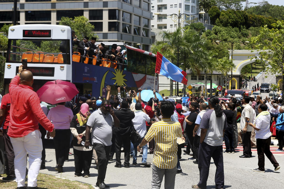 Lawmakers from the People's Justice Party on a double-decker bus wave to supporters as they head to the National Palace to meet the king in Kuala Lumpur, Malaysia, Wednesday, Feb. 26, 2020. Malaysia's king held unusual consultations with lawmakers for a second day Wednesday to resolve a political vacuum caused by the abrupt collapse of the ruling coalition and the resignation of Prime Minister Mahathir Mohamad. (AP Photo)