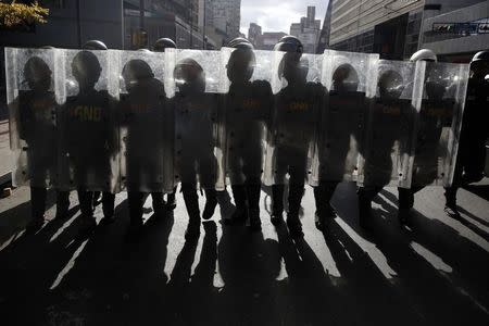 National Guards walk with their shields up as they keep guard during a street protest in support of jailed opposition leader Leopoldo Lopez in Caracas February 18, 2015. REUTERS/Carlos Garcia Rawlins