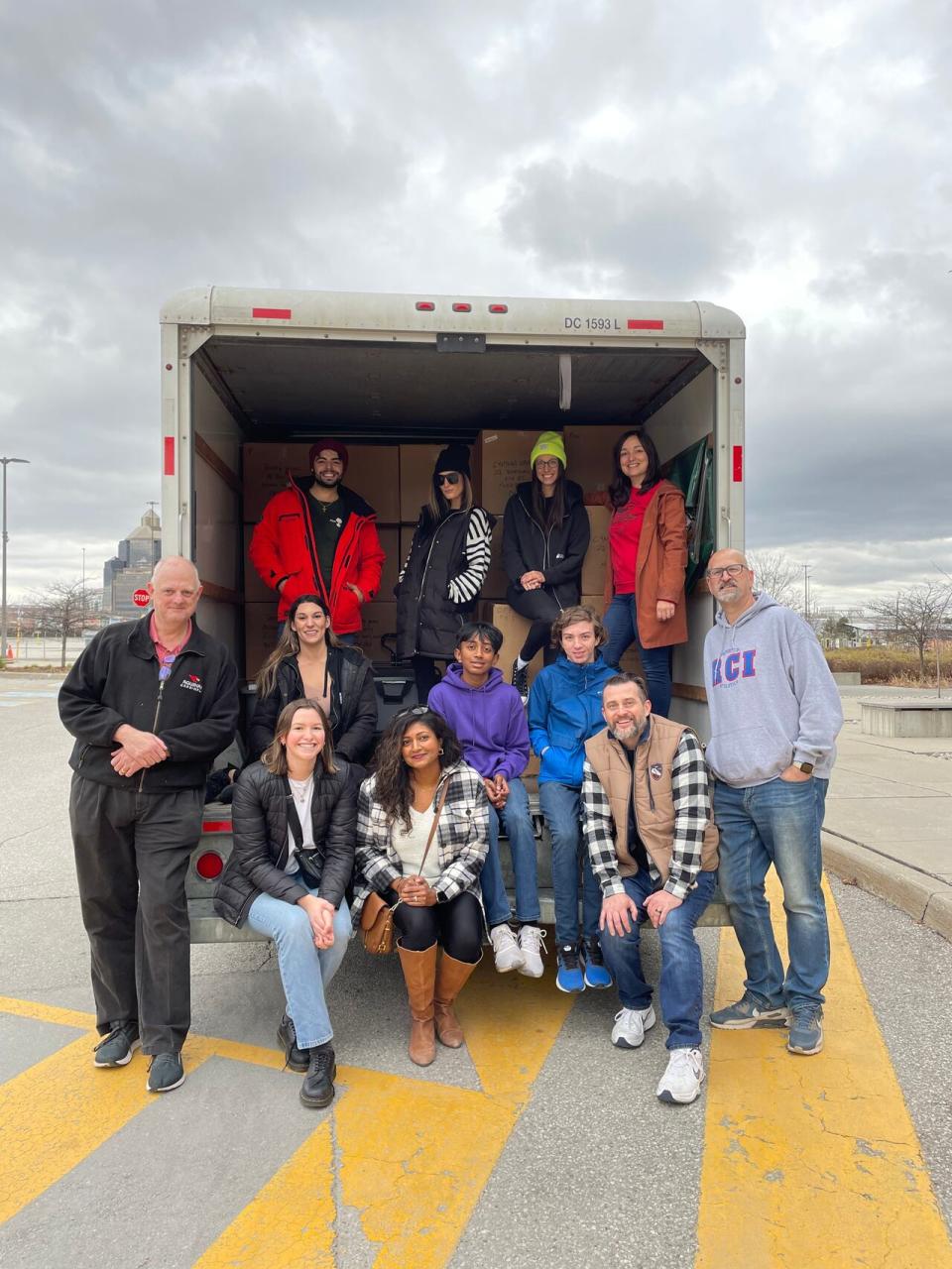People in front of a van packed with boxes of donated menstrual products to be shipped north. 
