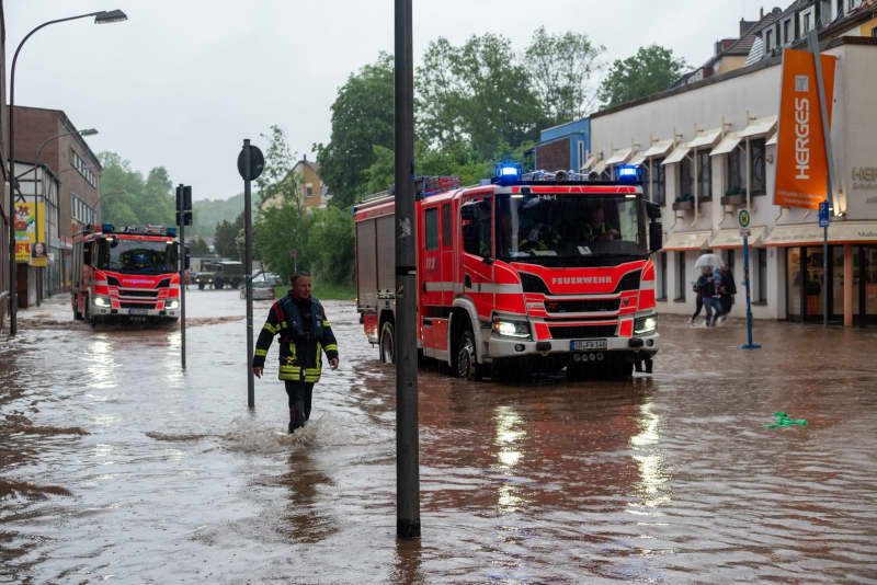 Firefighters move their trucks through the floods in Fischbachstrasse in Saarbruecken after heavy rainfall. Harald Tittel/dpa