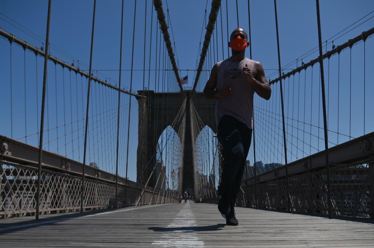 A person jogs over the Brooklyn Bridge,  amid the novel coronavirus, COVID-19, pandemic, on May 26, 2020 in New York City. (Photo by Angela Weiss / AFP) (Photo by ANGELA WEISS/AFP via Getty Images)