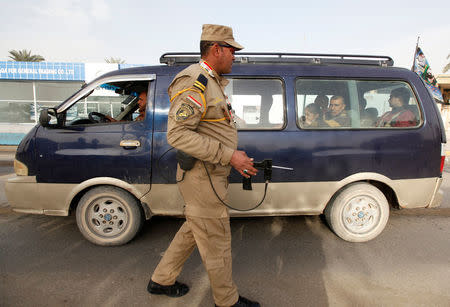 A security officer inspects a car using a scanning device at a checkpoint in Baghdad, December 13, 2013. REUTERS/Ahmed Saad/File Photo