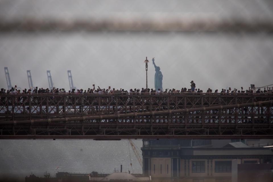 Demonstranten marschieren über die Brooklyn Bridge mit Blick auf die Freiheitsstatue. Foto: Michael Nagle / XinHua / dpa