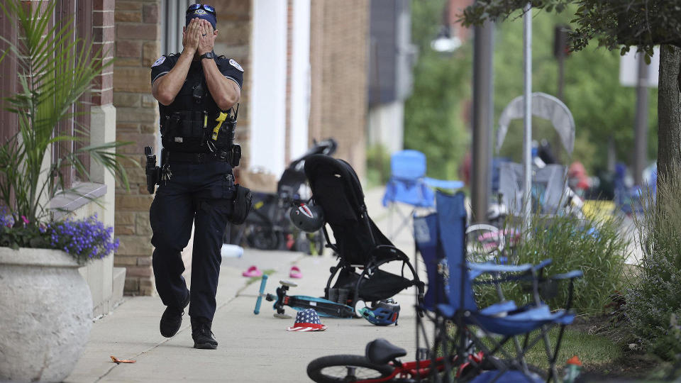 A Lake County, Illinois, police officer walks down Central Avenue in Highland Park on July 4, 2022, after a shooter fired on the Fourth of July parade. / Credit: Brian Cassella/Chicago Tribune/Tribune News Service via Getty Images