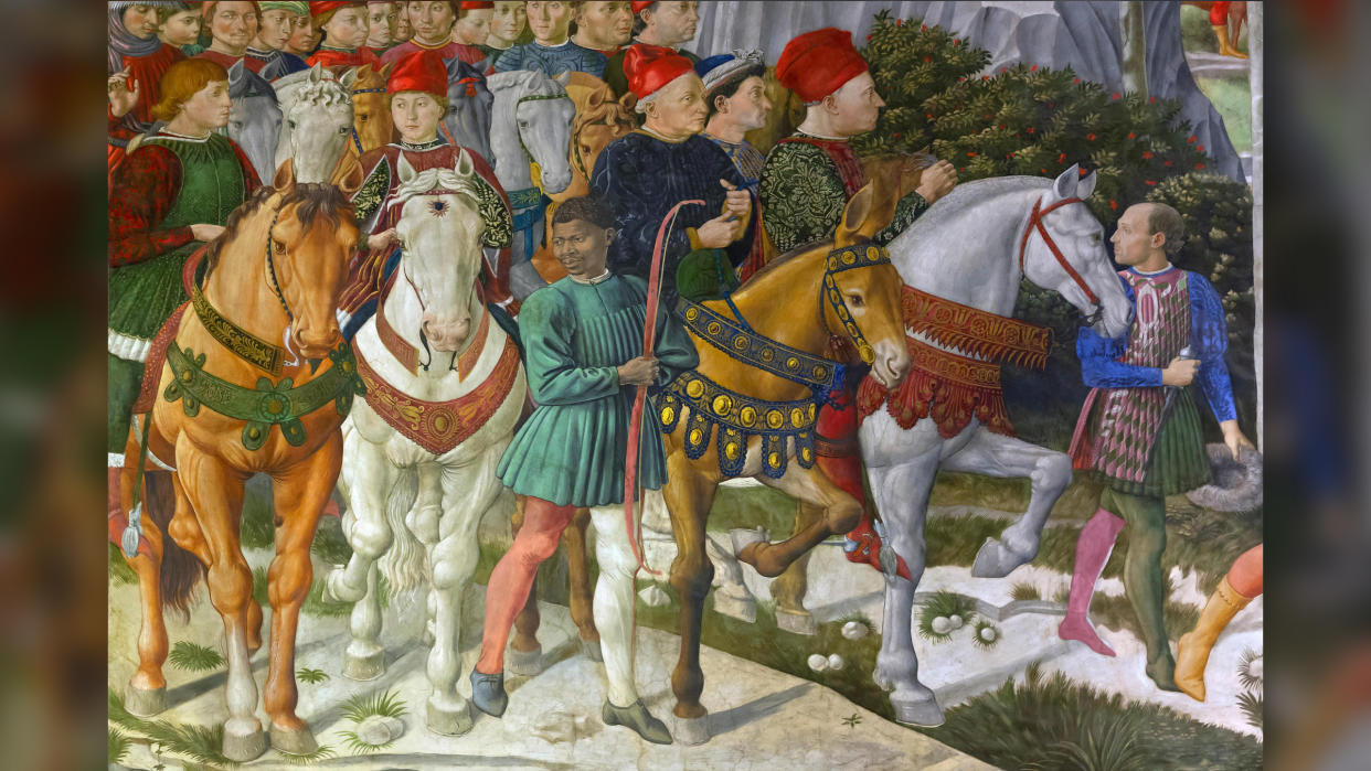  A Renaissance painting of the Medicis on horses going for a hunt. They are surrounded by people. 