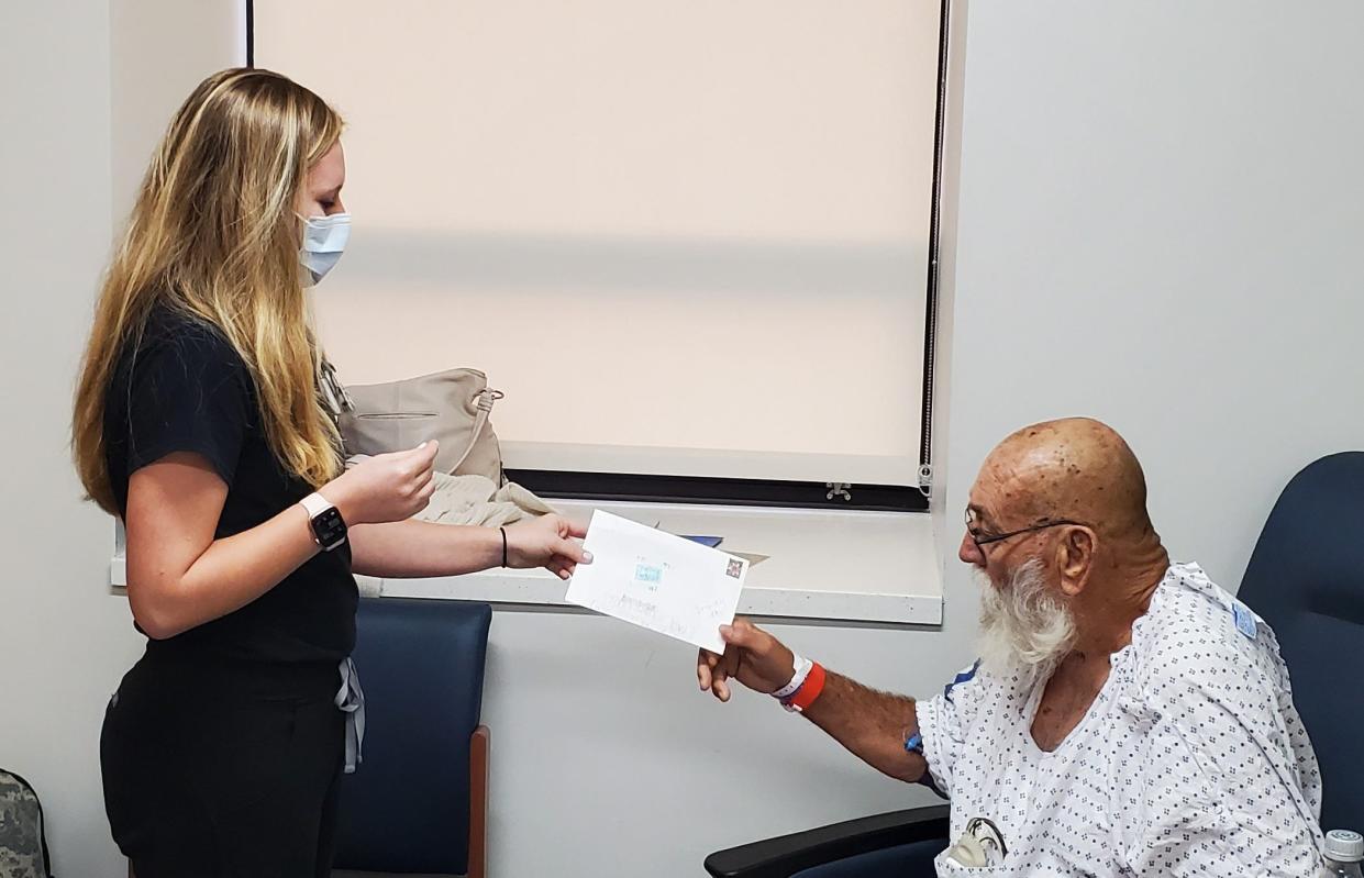 Registered Nurse Baleigh Roach hands her patient Herbert Linwood Oden Jr. a gift from a local elementary school student. The gift was addressed to the hospital for anyone who needed to have their day brightened up.