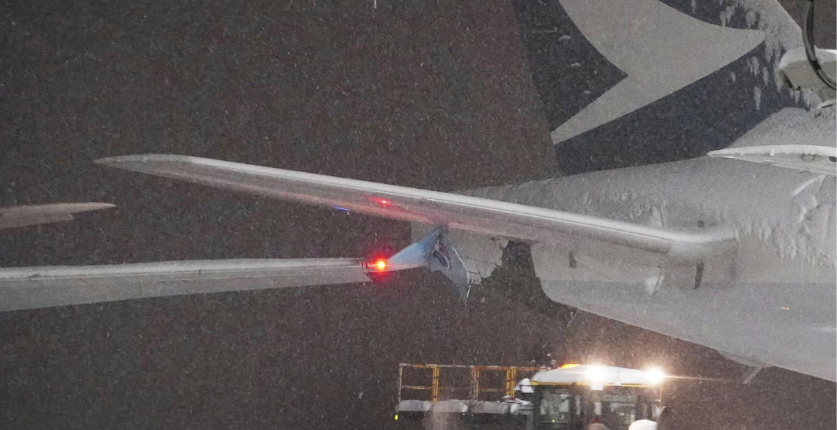 A part of wing of a Korean Air plane, left, and Cathay Pacific aircraft, right, are seen after the collision (AP)