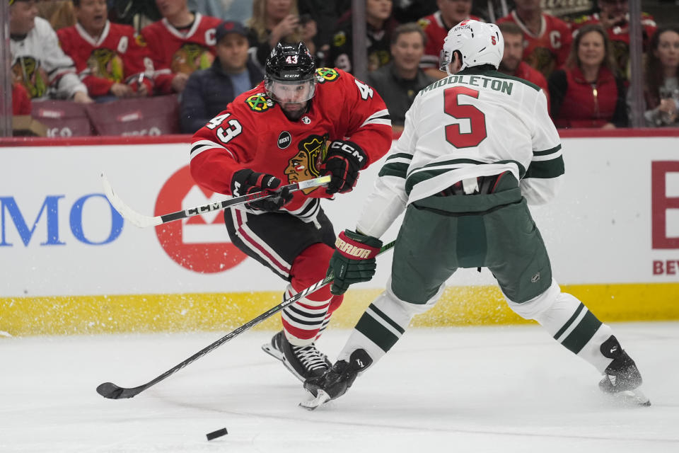 Minnesota Wild defenseman Jake Middleton, right, and Chicago Blackhawks center Colin Blackwell chase the puck during the second period of an NHL hockey game, Wednesday, Feb. 7, 2024, in Chicago. (AP Photo/Erin Hooley)