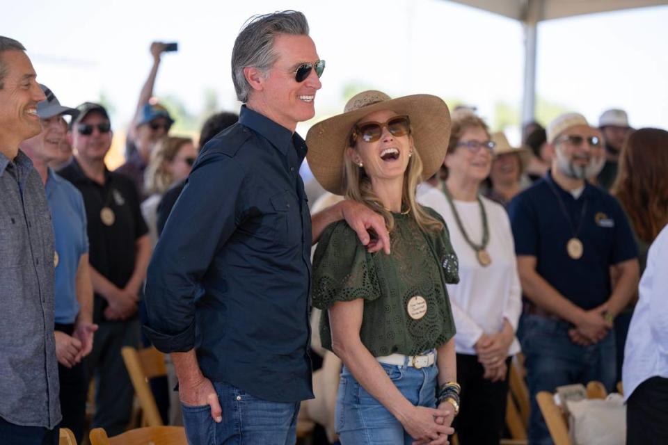 Gov. Gavin Newsom and First Partner Jennifer Siebel Newsom laugh during a speech by Dolores Huerta during the dedication of the new Dos Rios State Park in the San Joaquin Valley on April 22, 2024.