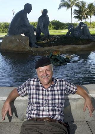 In this 2004 photo, D. J. Wilkins sits in the shade next to  the Uncommon Friends fountain at Centennial Park in downtown Fort Myers which he designed, sculpted and built in 1989.