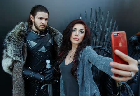 A woman shoots a selfie with an actor, dressed like Jon Snow, before the screening of final episode of Game of Thrones on 20-meter-high screen at RZD Arena in Moscow, Russia May 20, 2019. REUTERS/Maxim Shemetov