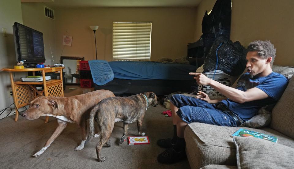 Longtime Southpark Apartments resident Brian Cosby directs his dogs Nyla (left) and Sai around his studio apartment June 28 in Columbus. Cosby says living in the apartments is "trash" and the complex should be torn down.