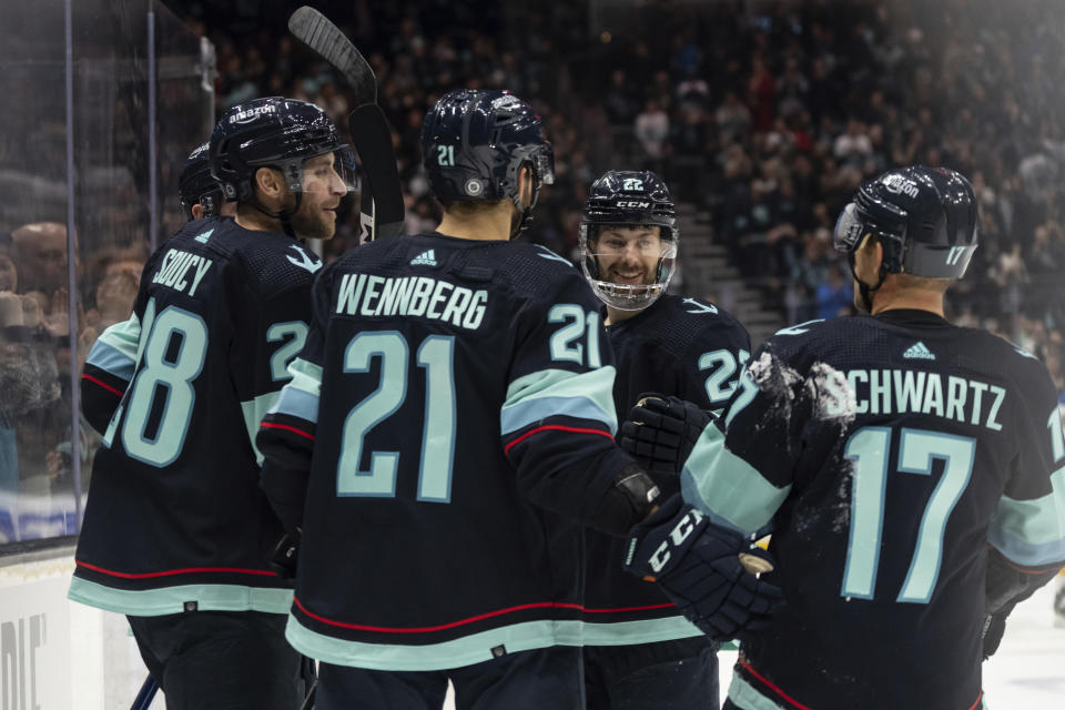 Seattle Kraken players, including forward Jaden Schwartz, right, forward Oliver Bjorkstrand, second from right, and forward Alex Wennberg, center, celebrate a goal by defenseman Carson Soucy, front left, against the St. Louis Blues during the second period of an NHL hockey game Tuesday, Dec. 20, 2022, in Seattle. (AP Photo/Stephen Brashear)