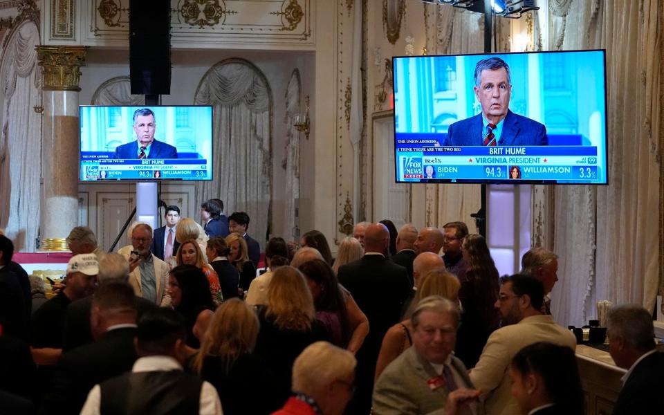 Screens show election results before Republican presidential candidate Donald Trump speaks at a Super Tuesday election night party