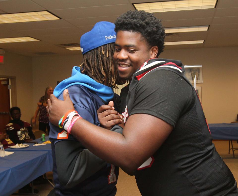 Tinell Edwards, right, of Buchtel, greets Tim Peake of Ellet after the Akron Public Schools Football Media Day on Wednesday in Akron. 
