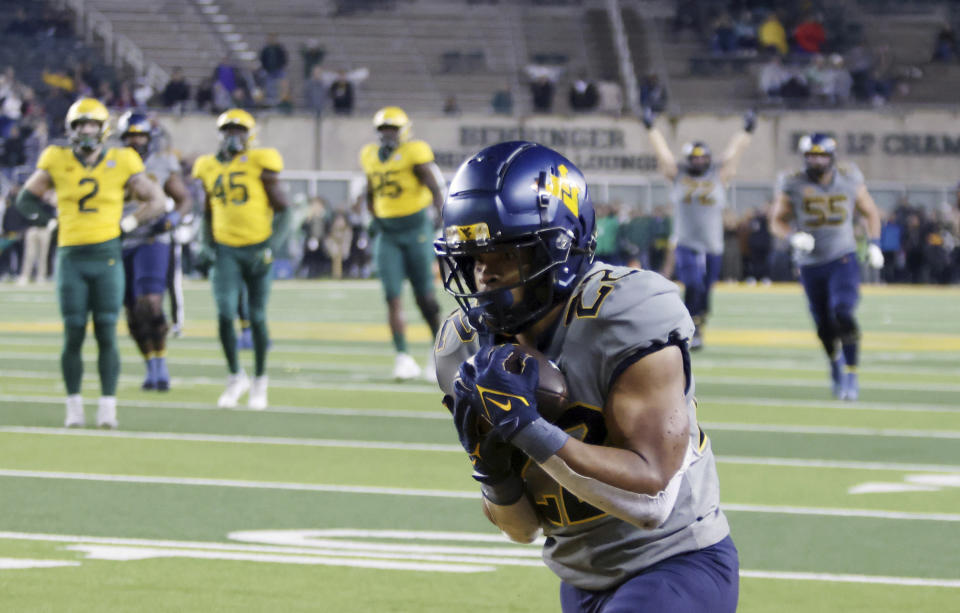 West Virginia running back Jahiem White pulls down a go-ahead touchdown while scoring against Baylor in the second half of an NCAA college football game, Saturday, Nov. 25, 2023, in Waco, Texas. (Rod Aydelotte/Waco Tribune-Herald, via AP)