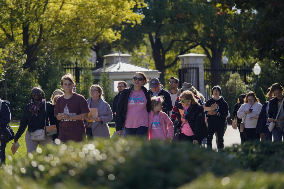 The first wave of visitors enters the South Lawn during the White House Fall Garden Tour in Washington, Saturday, Oct. 8, 2022. (AP Photo/Carolyn Kaster)