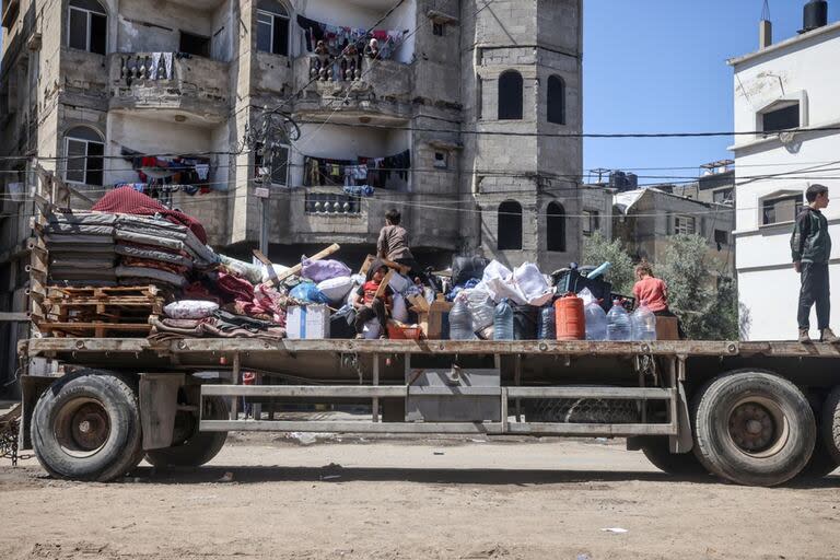 Palestinos desplazados en Rafah, en el sur de la Franja de Gaza, cargan sus pertenencias tras una orden de evacuación, el 6 de mayo (Archivo)