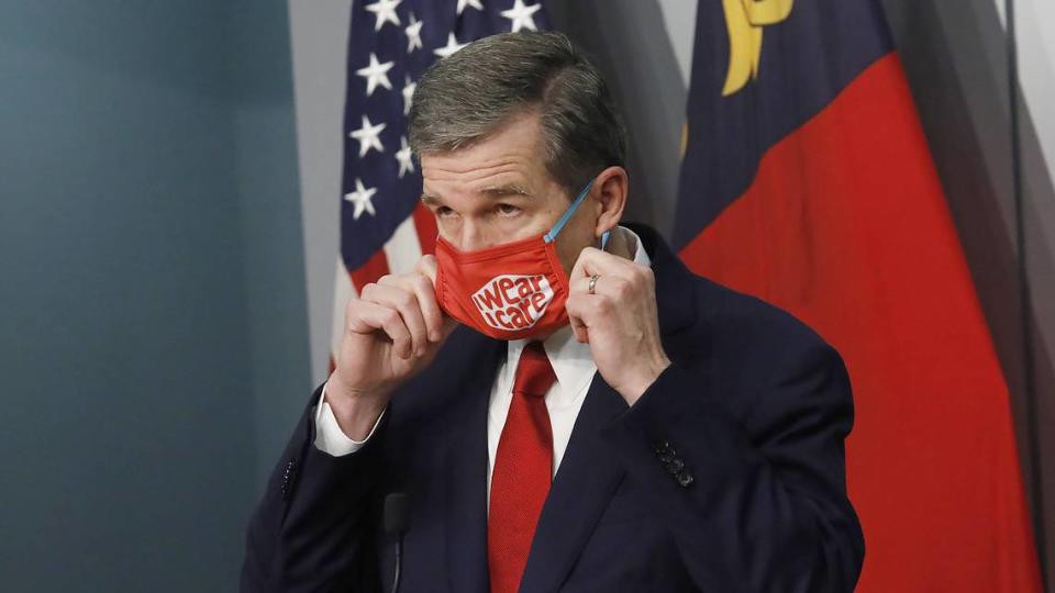 Gov. Roy Cooper removes his mask before speaking during a briefing on North Carolina’s coronavirus pandemic response Tuesday, Dec. 1, 2020 at the NC Emergency Operations Center in Raleigh.