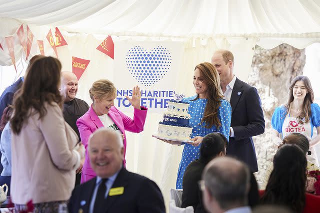 <p>Tom Dymond/REX Shutterstock</p> Kate Middleton, watched by baker Alice Fevronia (right) and host Mel Giedroyc carries in the cake