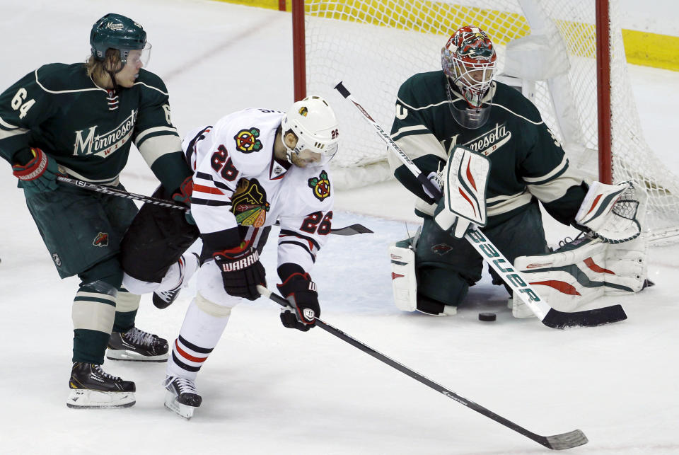 Chicago Blackhawks center Michal Handzus (26), of Czech Republic, gets a shot through the legs of Minnesota Wild goalie Ilya Bryzgalov, right, of Russia, to score in front of Wild center Mikael Granlund (64), of Finland, during the second period of Game 4 of an NHL hockey second-round playoff series in St. Paul, Minn., Friday, May 9, 2014. (AP Photo/Ann Heisenfelt)