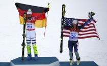 Winner Germany's Maria Hoefl-Riesch (L) and third-placed Julia Mancuso of the U.S. hold up their flags on the podium during the victory ceremony after the women's alpine skiing super combined event at the 2014 Sochi Winter Olympics at the Rosa Khutor Alpine Center February 10, 2014. REUTERS/Dominic Ebenbichler (RUSSIA - Tags: SPORT SKIING OLYMPICS)