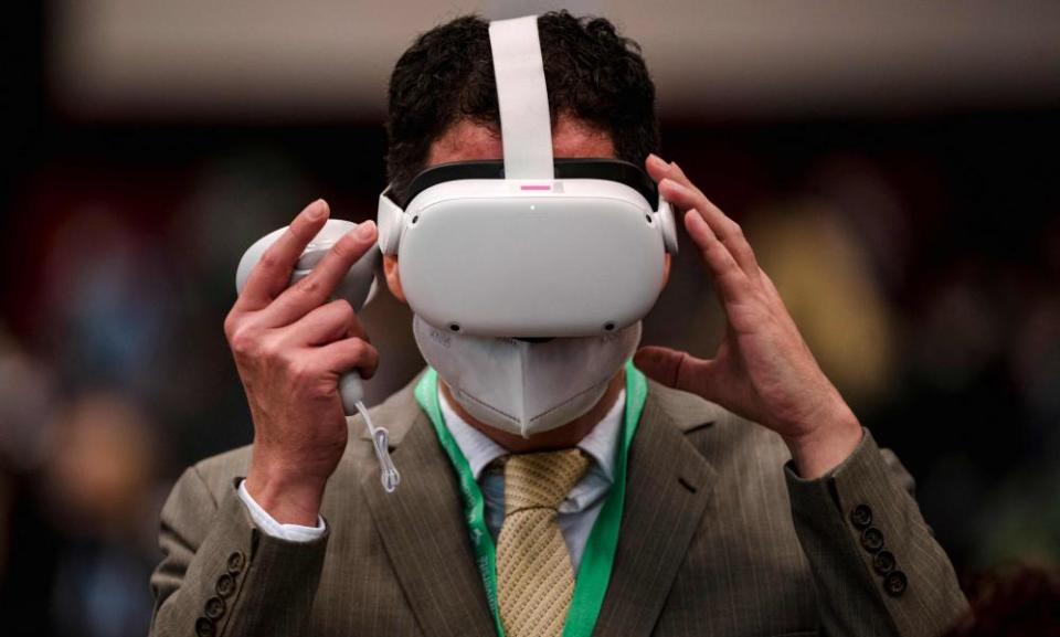 Masks are back …. in more ways than one. A Cop15 delegate plays with a VR headset.