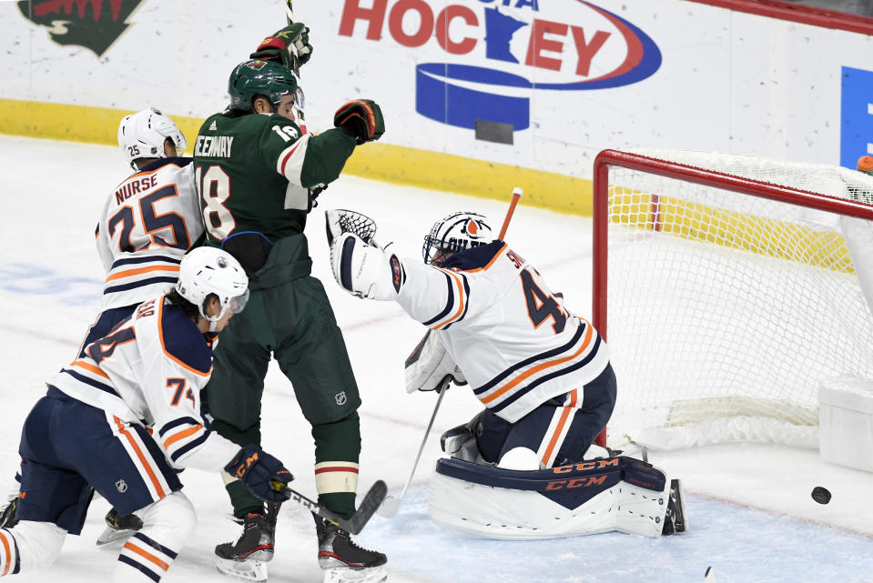 Minnesota Wild's Jordan Greenway, center, puts the puck past Edmonton Oilers goalie Mike Smith, right, for a goal in the first period of an NHL hockey game, Thursday, Dec.12, 2019, in St. Paul, Minn. (AP Photo/Tom Olmscheid)