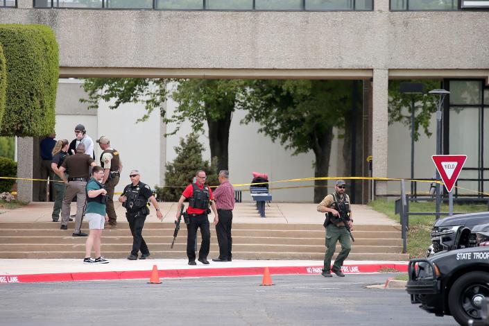 Law enforcement stand near the scene of a shooting that left one dead Monday on the campus of Rose State College in Midwest City.