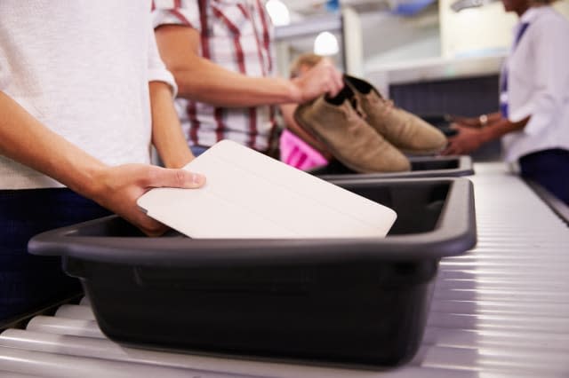 Man Puts Digital Tablet Into Tray For Airport Security Check