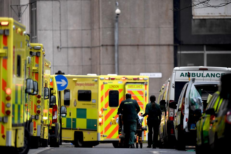 Paramedics wheel a patient on a trolley past a line of ambulances outside the Royal London hospital in London on January 12, 2021 as surging cases of the novel coronavirus are placing health services under increasing pressure. - People who flout coronavirus lockdown rules are putting lives at risk, the British government said on Tuesday, as cases surge to record highs and rumours swirl of potentially tougher restrictions. Britain is currently in its third lockdown, with schools and non-essential shops closed, as a new strain of the virus spreads rapidly across the country. (Photo by DANIEL LEAL-OLIVAS / AFP) (Photo by DANIEL LEAL-OLIVAS/AFP via Getty Images)