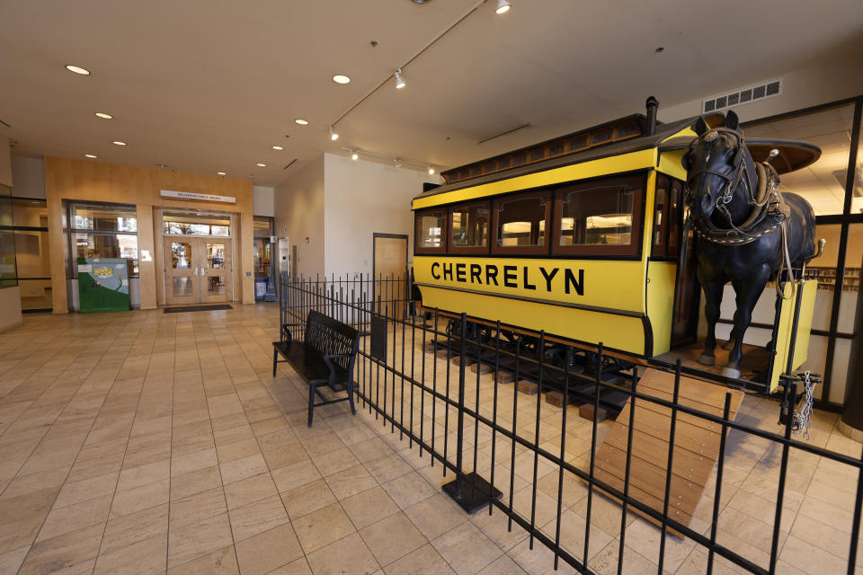 A restored Cherrelyn horsecar that used to run between Denver and Englewood, Colo., stands in the lobby of city hall outside the main doors to the library Thursday, Jan. 12, 2022, in the south Denver suburb of Englewood. The library and a restroom are closed in the building because of meth contamination. (AP Photo/David Zalubowski)