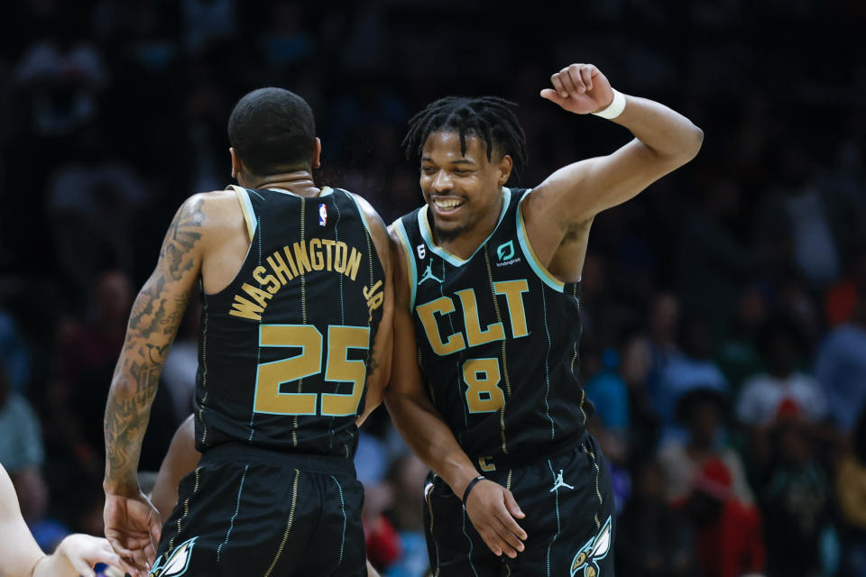 Charlotte Hornets guard Dennis Smith Jr. (8) celebrates with Charlotte Hornets forward P.J. Washington after Smith dunked against the Dallas Mavericks during the second half of an NBA basketball game in Charlotte, N.C., Sunday, March 26, 2023. Charlotte won 110-104. (AP Photo/Nell Redmond)