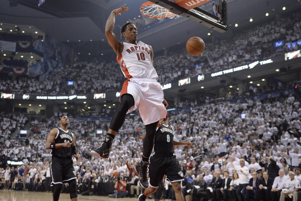 Toronto Raptors' DeMar DeRozan (10) dunks as Brooklyn Nets' Paul Pierce (34) and Deron Williams (8) look on during the first half of Game 5 of the opening-round NBA basketball playoff series in Toronto, Wednesday, April 30, 2014. (AP Photo/The Canadian Press, Frank Gunn)