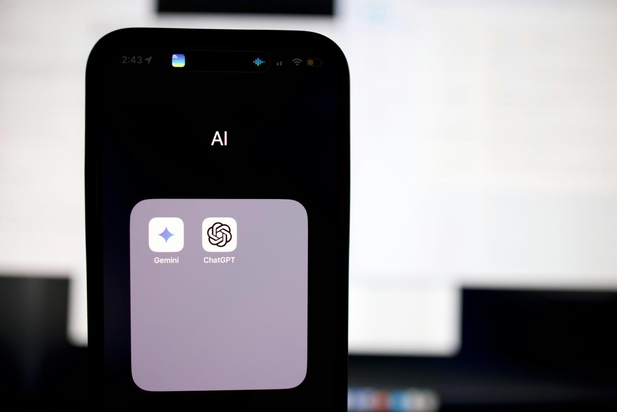  A phone screen with the words "AI" printed above OpenAI and Gemini apps. 