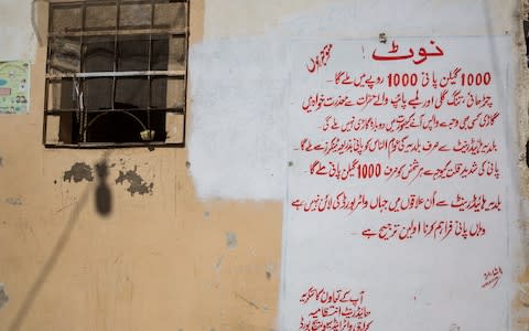 A hand painted note on the outside wall of an office located in Baldiya, at an illegal hydrant in Karachi’s West District on December 6, 2018. The sign says: “You will receive 1000 gallon for 1000 PKR. Uphill areas, cramped lanes will not be provided the water and we apologize in advance. If for any reason the tanker is returned, you will not be provided with another. Only the residents of Baldiya residents will be provided the water tankers. Due to the severe shortage of water, only 1000 gallon would be provided per person.”  - Credit: Insiya Syed/The Telegraph