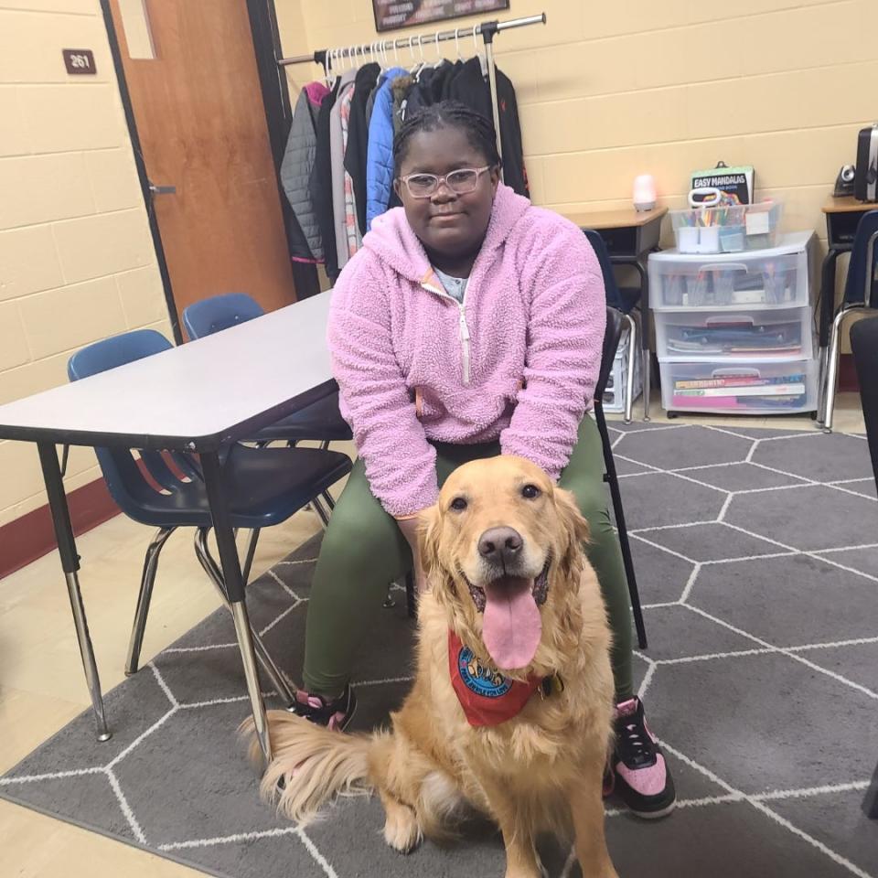 Licking Heights sixth grader Cierra Campbell with the district's new therapy dog, 5-year-old Ollie. Ollie supports students dealing with depression, anxiety, grief or who just need a little puppy love.