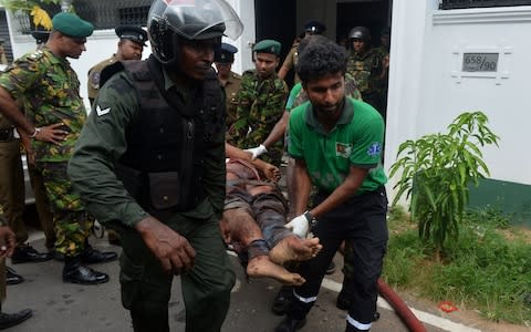 An injured Sri Lankan Special Task Force soldier is carried by colleagues after a blast in a house, which was detonated as security forces searched the property, in the Orugodawatta area of the capital Colombo - Credit: &nbsp;ISHARA S. KODIKARA/AFP